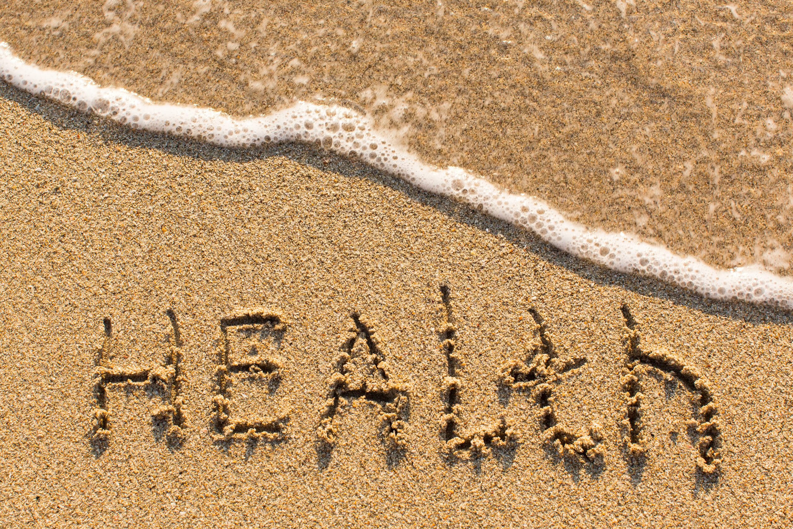 Health - word drawn on the sand beach with the soft wave.